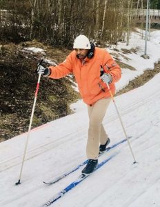 Student in orange jacket skiing