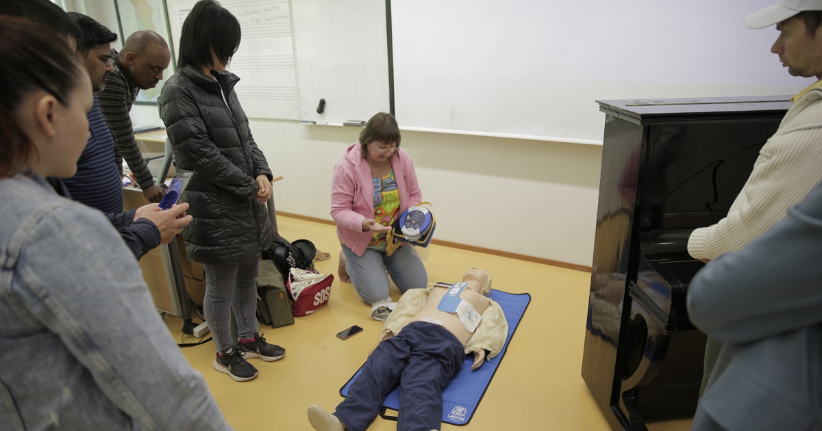 students gathered around teacher and mannequin.